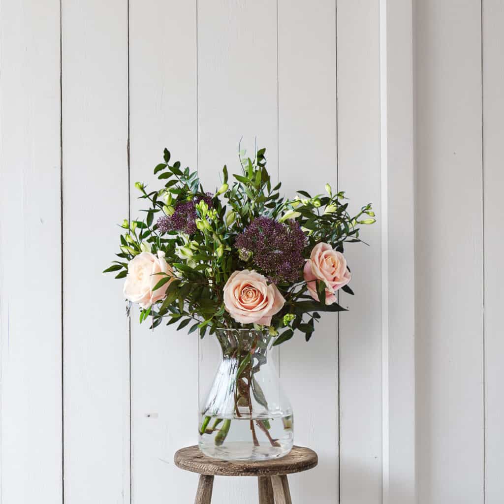 A bunch of pink roses and greenery by Freddies flowers
