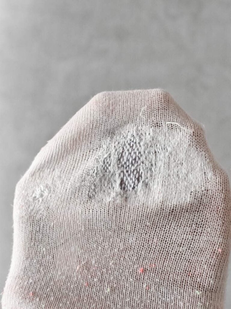 A close-up of a mended sock, with the repaired area blending into the fabric.