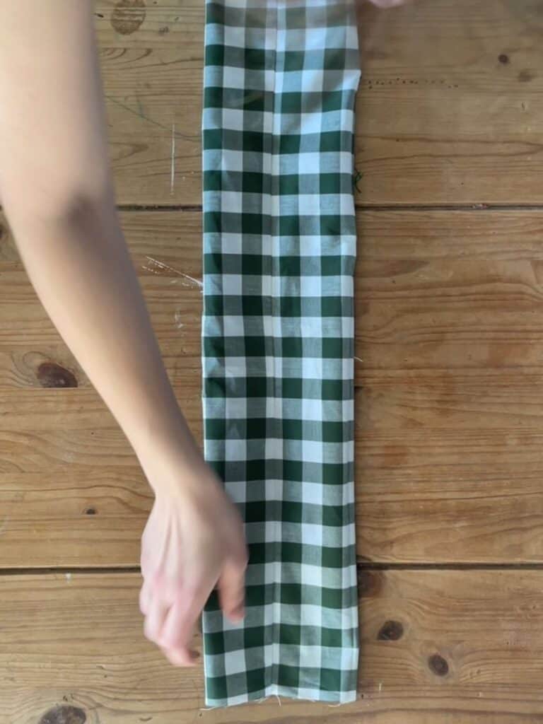 The fabric folded again, forming the base shape of the bow before sewing or securing the layers.