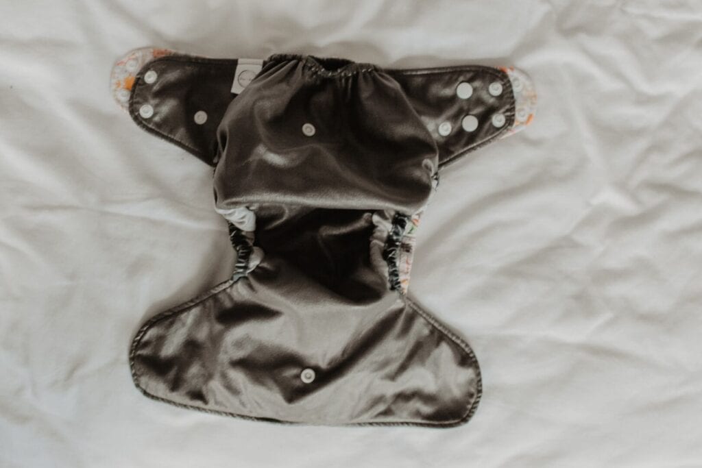The Bare & Boho V2 cloth nappy on top of the V3 version. The V3 has longer tabs, but otherwise the two one size nappies are similar in shape and size.