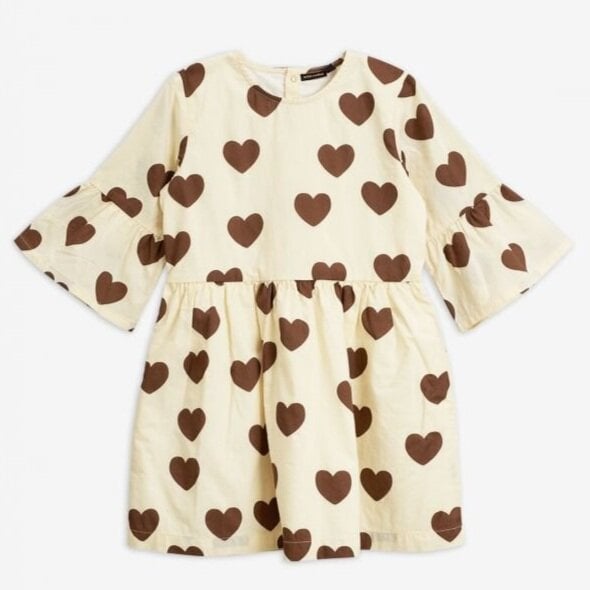 A cream-colored Mini Rodini dress adorned with large brown heart patterns. The dress features three-quarter flared sleeves and a gathered waist.