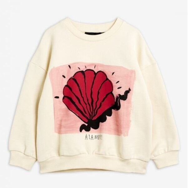 A cream-colored sweater featuring a large red seashell design on the front, with black accents and the words À LA MER ! underneath. The background of the design is a soft pink rectangle.